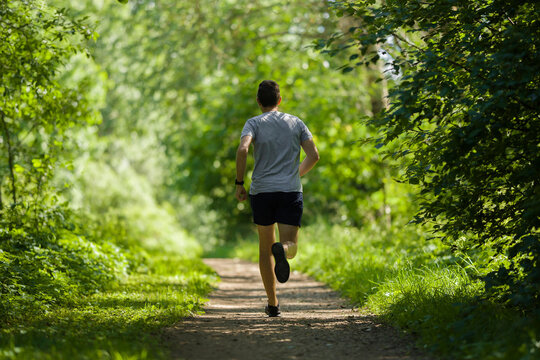 Fitness enthusiast tying running sneakers before outdoor training